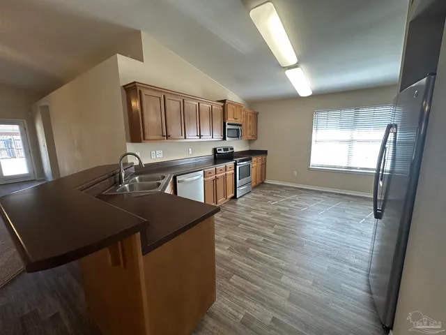 a kitchen with stainless steel appliances granite countertop a sink wooden cabinets and a granite counter tops