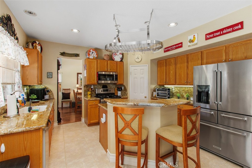 33370 Morning View Drive Temecula, CA 92592 - Photo 16 of 41 a kitchen with stainless steel appliances kitchen island granite countertop a refrigerator and a stove top oven