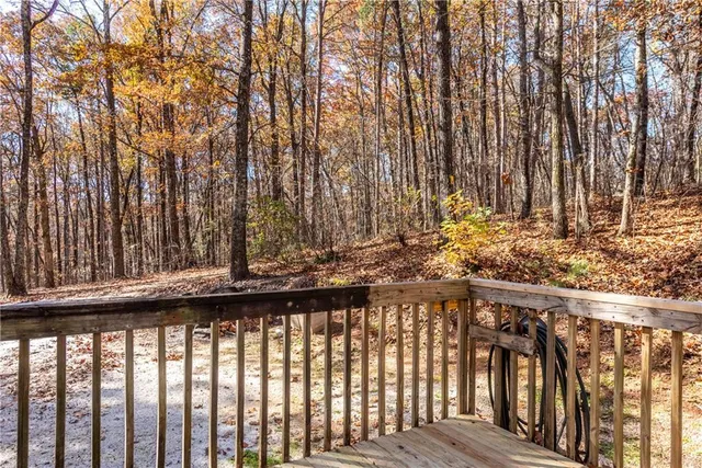 a view of backyard with wooden fence and large trees