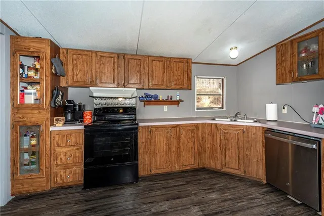 a kitchen with kitchen island granite countertop wooden cabinets and a stove