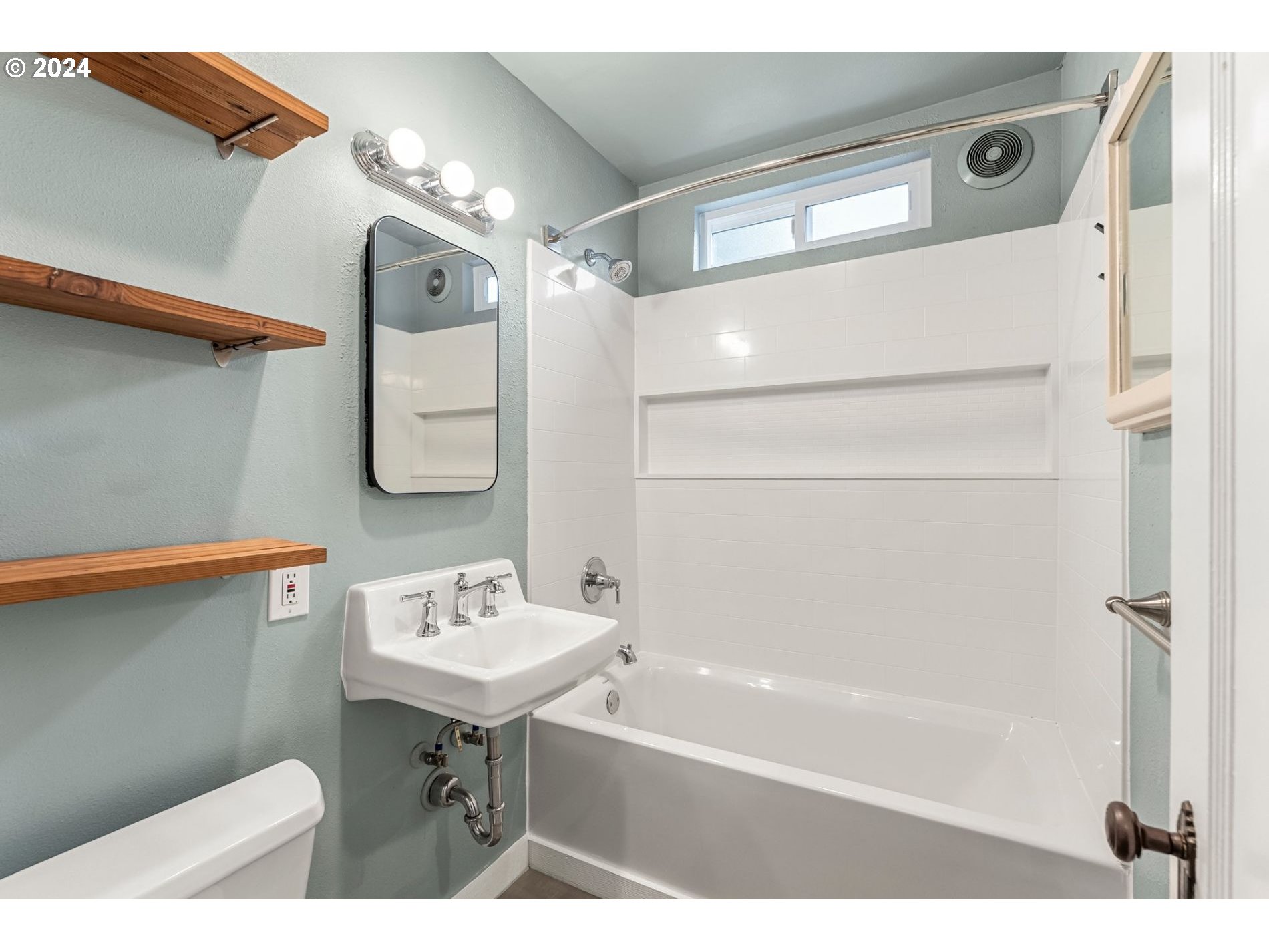1343 West Broadway Eugene, OR 97402 - Photo 4 of 10 a bathroom with a sink a mirror and a bathtub