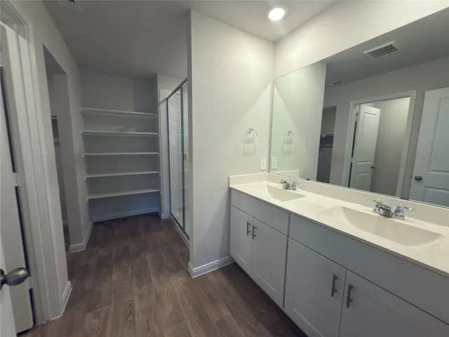 a bathroom with a double vanity sink and mirror