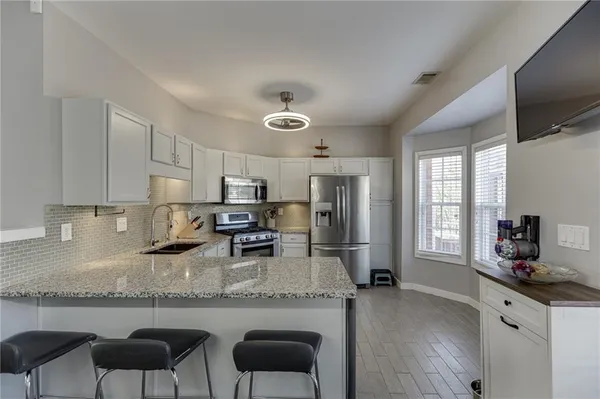 a kitchen with granite countertop a counter space a sink appliances and cabinets