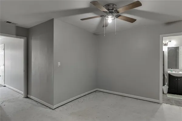 an empty room with closet and a chandelier fan