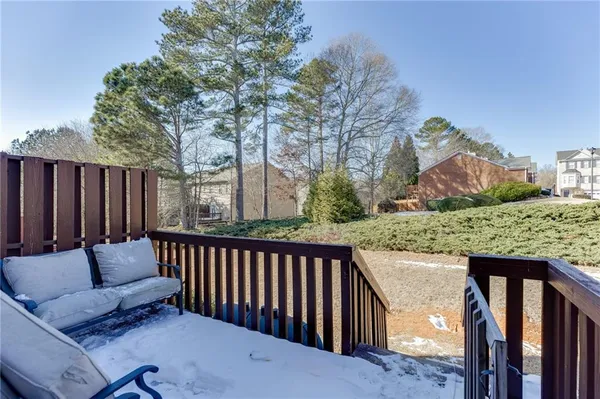 a view of roof deck with couches and wooden fence