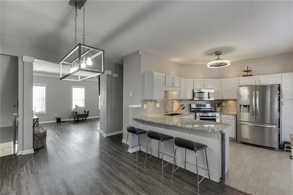 a kitchen with refrigerator a sink and wooden floor