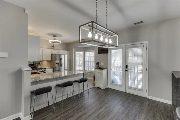 a view of a dining room with furniture a chandelier and wooden floor