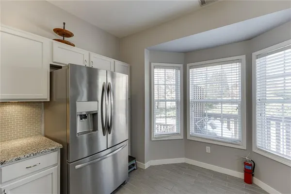 a metallic refrigerator freezer sitting in a kitchen