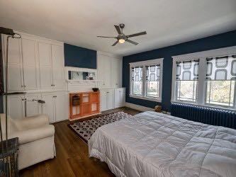 1331 Beechwood Boulevard Pittsburgh, PA 15217 - Photo 14 of 25 a bedroom with a large bed a flat tv screen and a fireplace