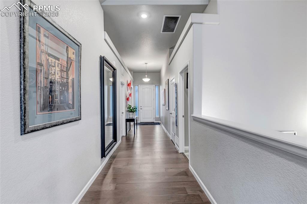 11830 Alydar Loop Colorado Springs, CO 80921 - Photo 15 of 37 a view of a hallway with wooden floor and staircase