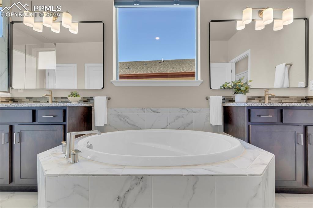 11830 Alydar Loop Colorado Springs, CO 80921 - Photo 22 of 37 a bathroom with a tub sink and mirror