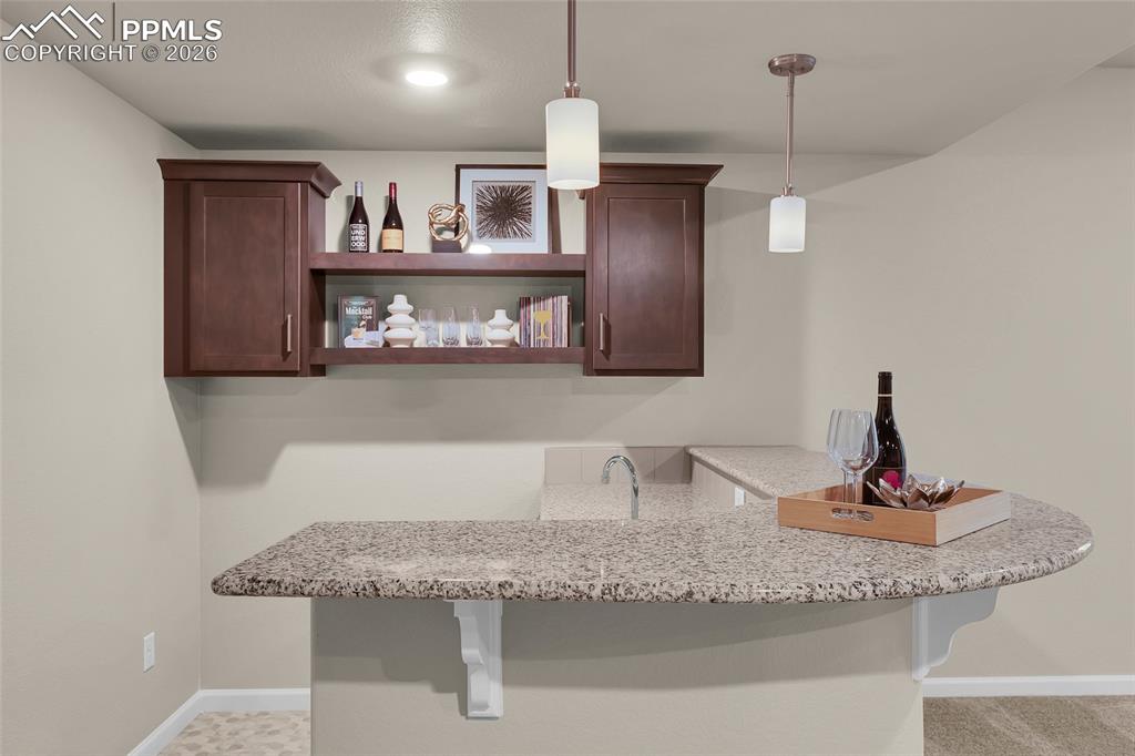 11830 Alydar Loop Colorado Springs, CO 80921 - Photo 29 of 37 a kitchen with granite countertop a sink and cabinets