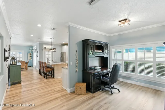a view of a workspace with furniture and a window