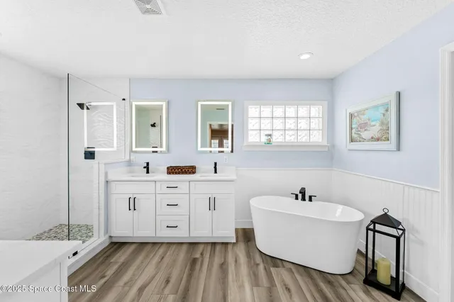 a bathroom with a sink mirror and a bathtub