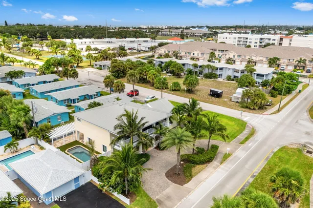 an aerial view of residential houses with outdoor space and swimming pool