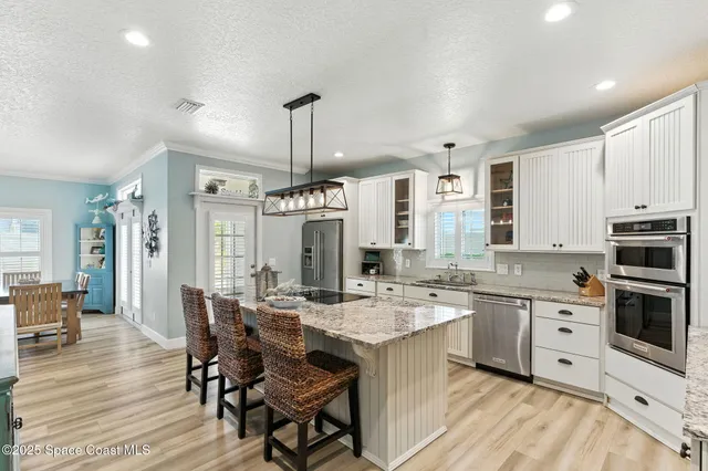 a open kitchen with stainless steel appliances kitchen island granite countertop a sink and cabinets