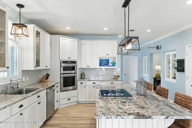 a kitchen with kitchen island granite countertop a stove oven and a sink with granite countertops