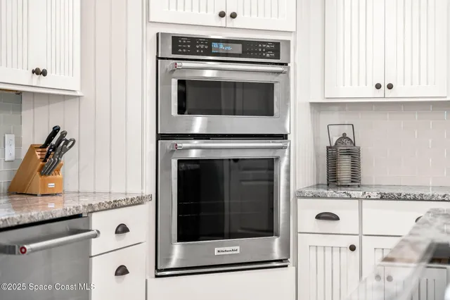 a kitchen with granite countertop a stove microwave and sink