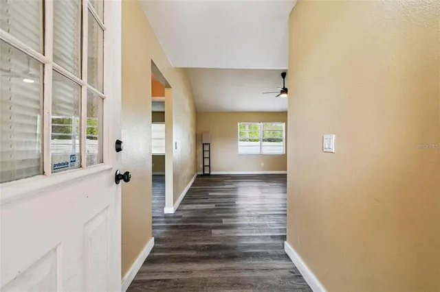 a view of a hallway with wooden floor and windows