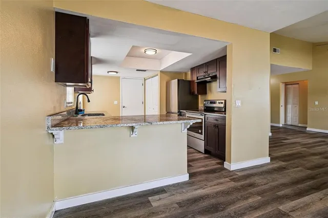 a view of kitchen with refrigerator microwave and stove