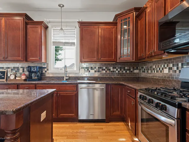 a kitchen with stainless steel appliances granite countertop a stove a sink dishwasher and a microwave oven with cabinets