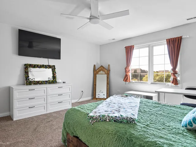 a bedroom with a bed flat screen tv and a window