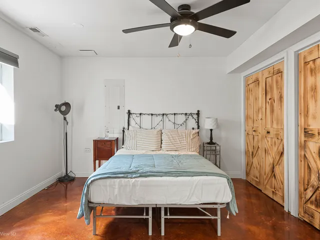 a bedroom with a bed and wooden floor