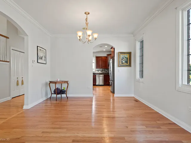 a view of a dining room with furniture a chandelier and wooden floor
