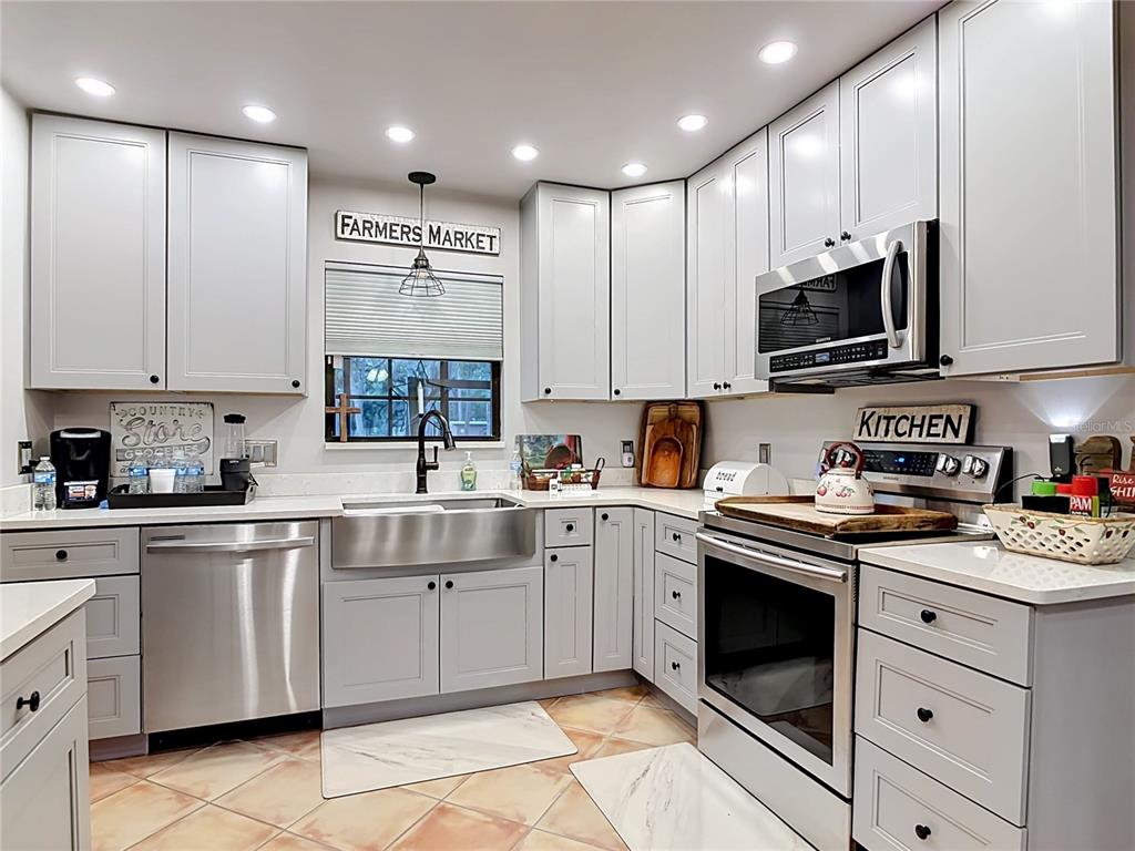 1395 Maytown Road Osteen, FL 32764 - Photo 26 of 65 a kitchen with kitchen island granite countertop white cabinets stainless steel appliances and sink