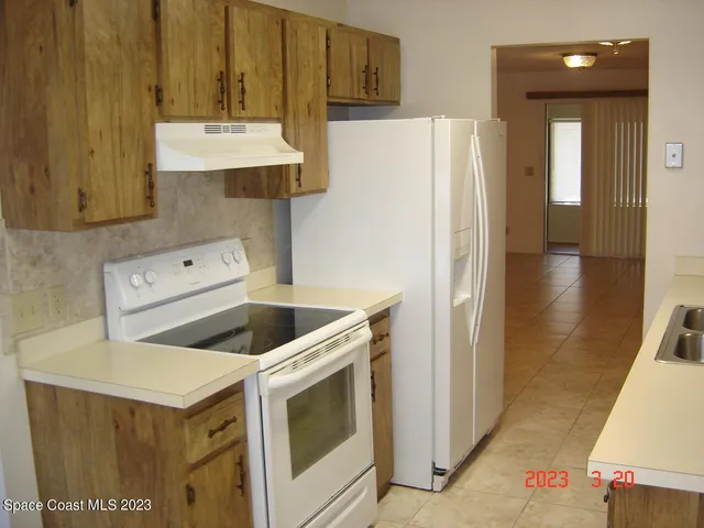 a kitchen with a refrigerator sink and cabinets