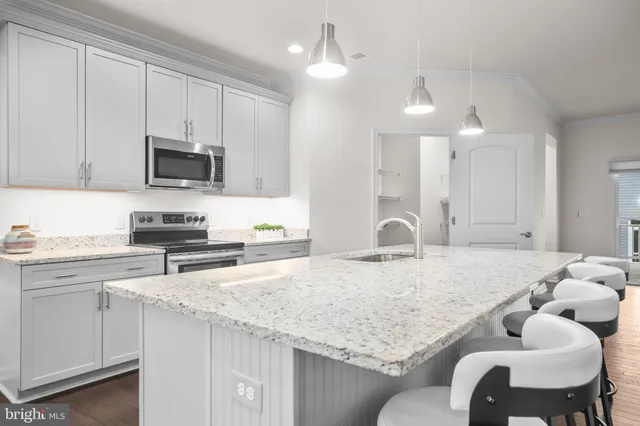 a kitchen with granite countertop a stove a sink and a refrigerator