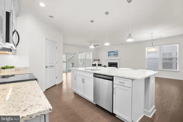 a kitchen that has a lot of white cabinets and wooden floor