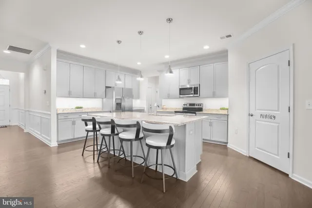 a kitchen with kitchen island granite countertop wooden floors and white stainless steel appliances