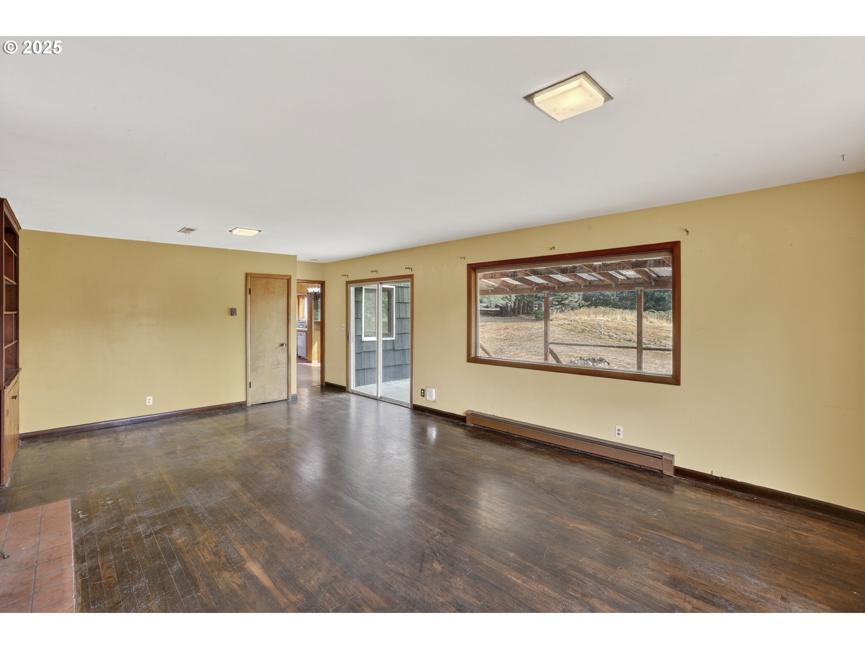 31444 New Kirk Road Scappoose, OR 97056 - Photo 9 of 43 a view of an empty room with wooden floor and a window