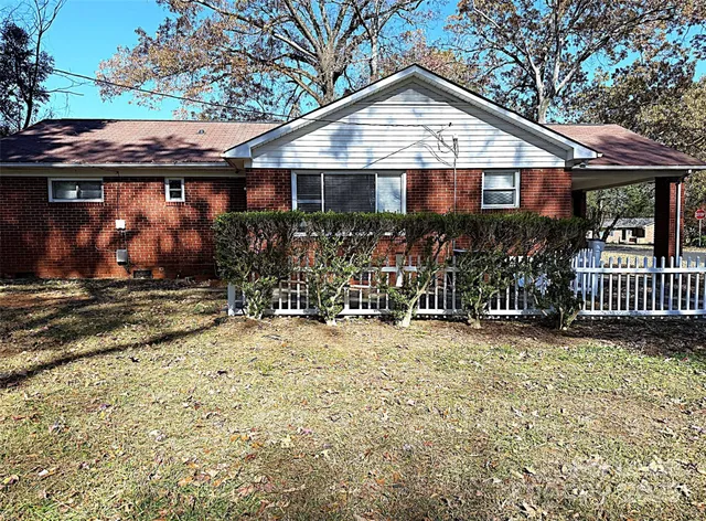 a view of a house with a yard and wooden fence