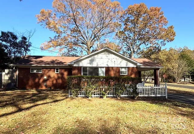 a front view of a house with a yard covered with snow