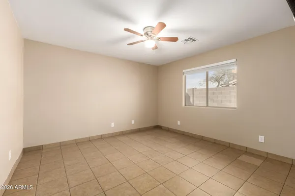 an empty room with windows and ceiling fan