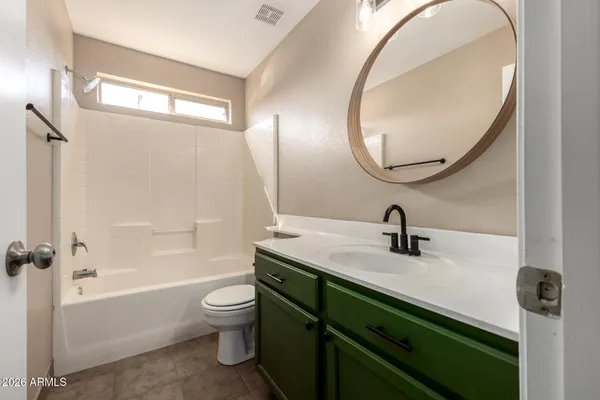 a bathroom with a granite countertop sink a toilet and a mirror