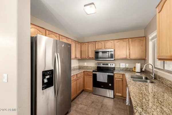 a kitchen with stainless steel appliances granite countertop a refrigerator stove and sink