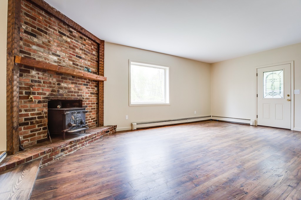 233 Middle Road Newbury, MA 01922 - Photo 11 of 30 an empty room with wooden floor fireplace and windows