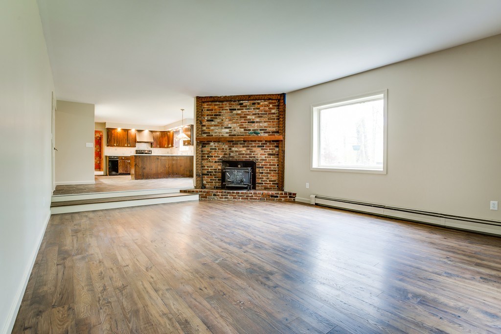 233 Middle Road Newbury, MA 01922 - Photo 12 of 30 an empty room with wooden floor fireplace and windows