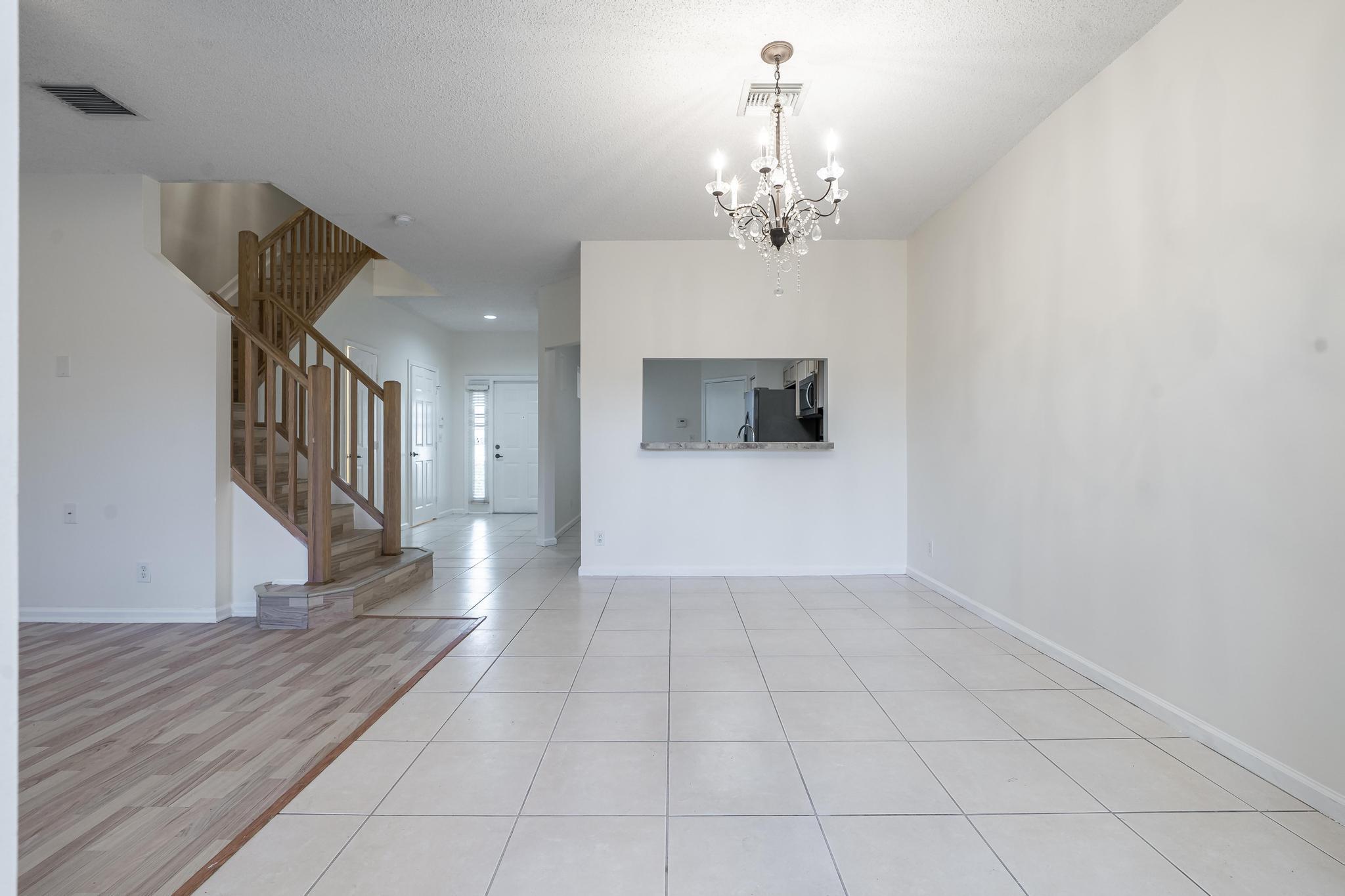8271 Vía Serena Boca Raton, FL 33433 - Photo 11 of 33 a view of a hallway with wooden floor and a kitchen space