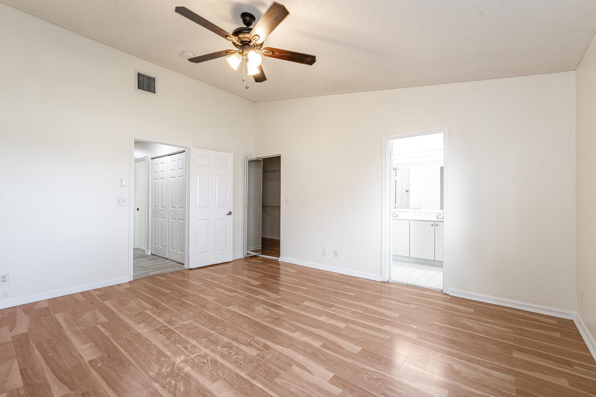 8271 Vía Serena Boca Raton, FL 33433 - Photo 16 of 33 a view of a big room with wooden floor and a ceiling fan