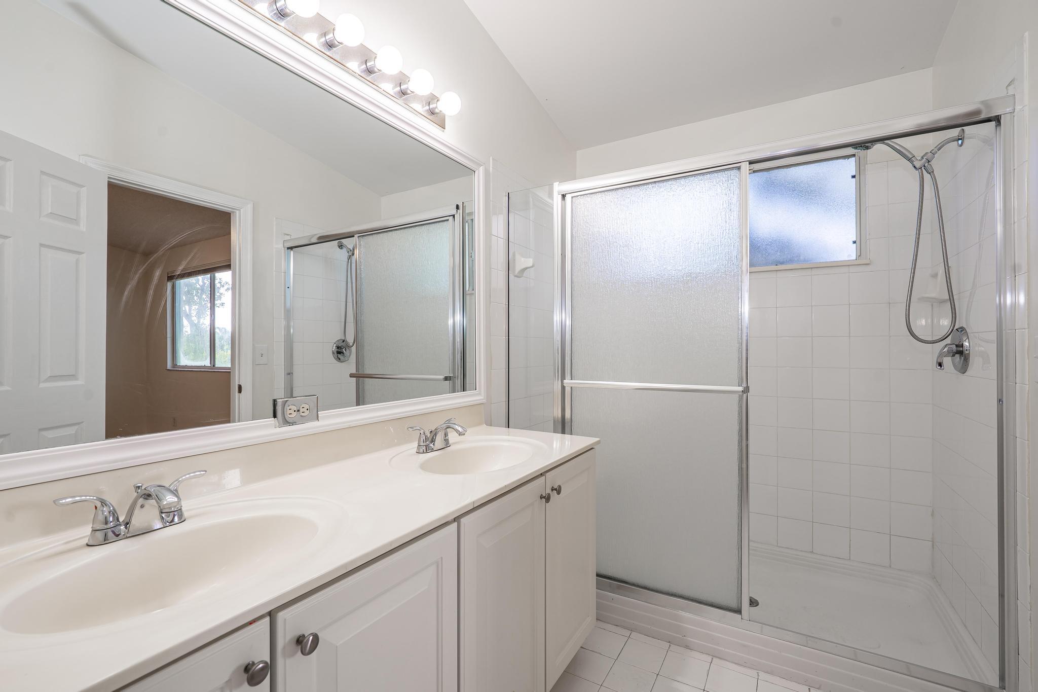 8271 Vía Serena Boca Raton, FL 33433 - Photo 19 of 33 a bathroom with a double vanity sink mirror and shower