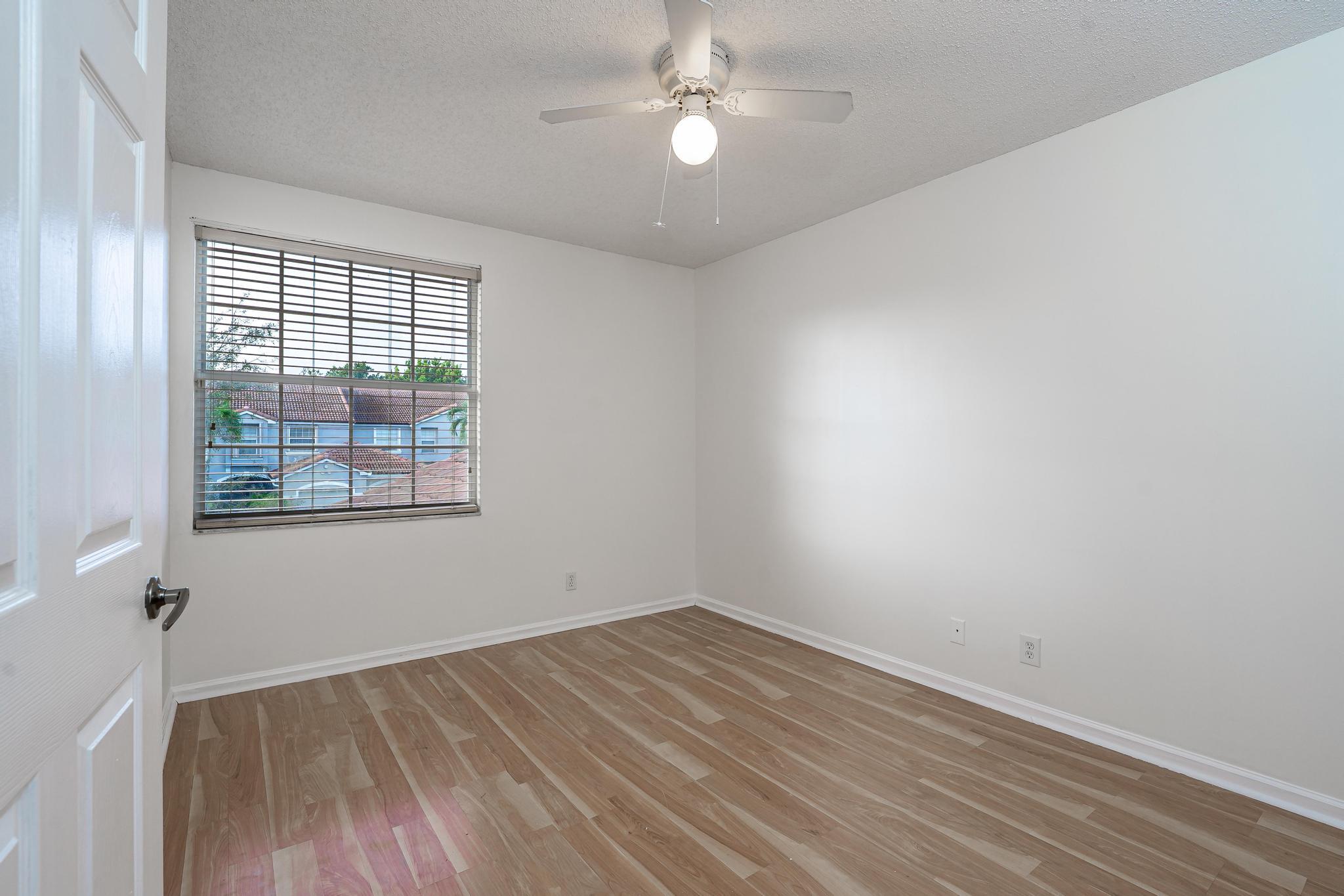 8271 Vía Serena Boca Raton, FL 33433 - Photo 22 of 33 wooden floor in an empty room with a window