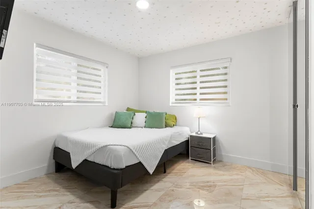 a bedroom with a bed lamp and a window