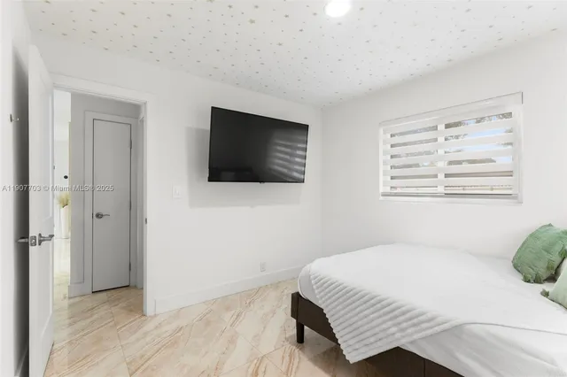 a bedroom with a bed and a flat screen tv