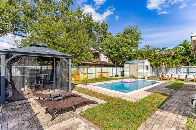 a view of a house with swimming pool and sitting area