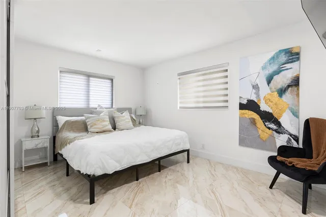 a bedroom with a bed a chair and a potted plant