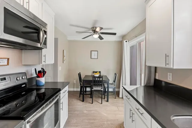 a kitchen with stainless steel appliances granite countertop a sink stove and microwave